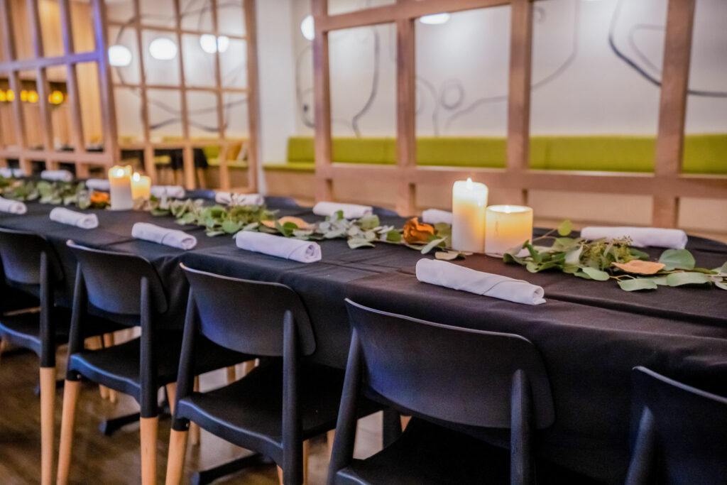 eucalyptus leaf centerpieces on dining tables in the event space at Perch + Plow